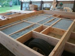We're building around the wheel wells rather than over them. The center section is double thick, so insulation over the wheel well area won't be a problem.